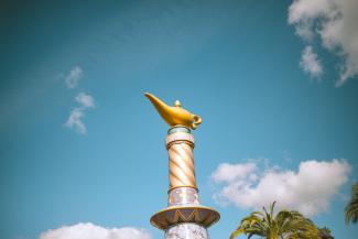 a gold and white statue of a fish on top of a fountain by Cesira Alvarado courtesy of Unsplash.