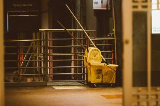 yellow plastic trash bin beside black metal stair railings by Jon Tyson courtesy of Unsplash.