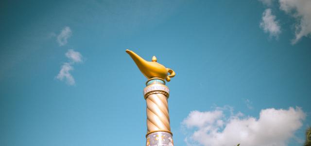 a gold and white statue of a fish on top of a fountain by Cesira Alvarado courtesy of Unsplash.